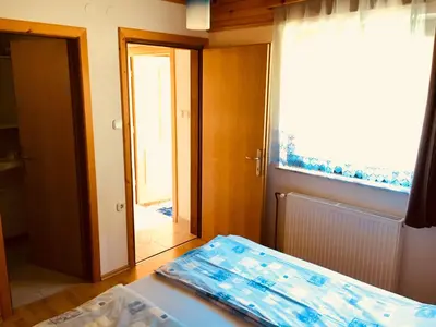 a room with a bed and a window and a door at Apartment Tisa in Solčava