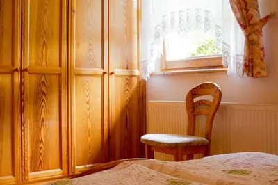 a bedroom with a bed and a chair and a window at Tourist farm Mraz in Podčetrtek