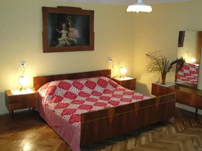 a bedroom with a bed with a red and white quilt at Authentic traditional Soca Valley home in Kanal
