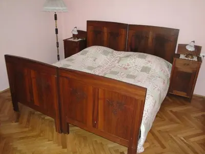 a wooden bed in a bedroom with two night stands at Authentic traditional Soca Valley home in Kanal