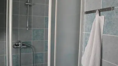 a bathroom with a shower and a white towel at Authentic traditional Soca Valley home in Kanal