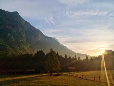 a field with a fence in front of a mountain at Apartment Joži in Soča