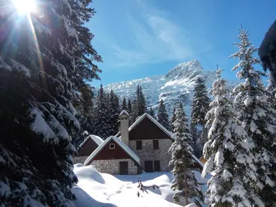 a church in the snow with a mountain in the background at Apartment Joži in Soča