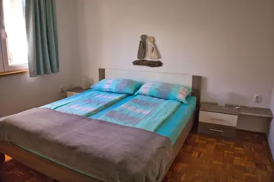 a bedroom with a bed with blue sheets at Apartma Javoršček in Bovec
