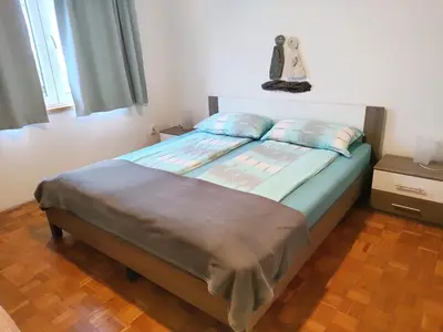 a bedroom with a large bed with blue pillows at Apartma Javoršček in Bovec