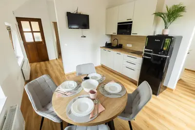 a kitchen with a wooden table with chairs and a dining room at Apartment Ajda Bled in Bled