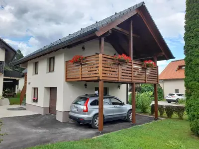 a car parked in front of a house with a balcony at Apartment Ajda Bled in Bled