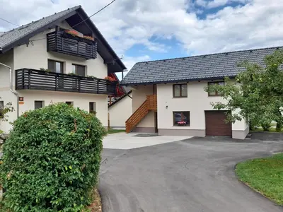 a white house with a black roof and a driveway at Apartment Ajda Bled in Bled