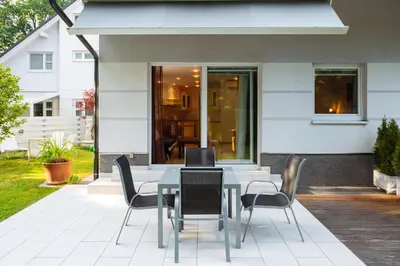 a dining table and chairs on a patio at Apartments Patricia in Bled