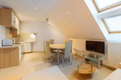 a kitchen and dining room with a table and a tv at Apartments Patricia in Bled