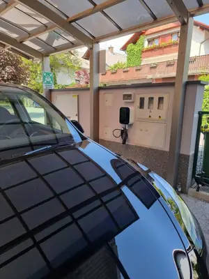a blue car parked in front of a garage at Apartments Patricia in Bled