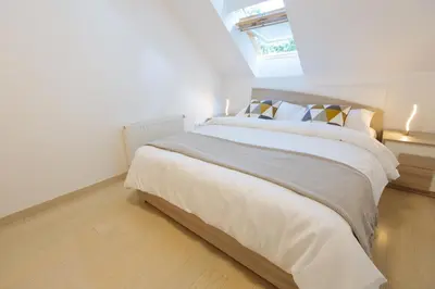 a bedroom with a large bed with white sheets and pillows at Apartments Patricia in Bled