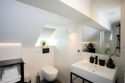 a white bathroom with a toilet and a sink at House 24 Bled in Bled