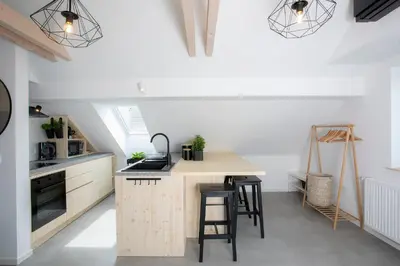 a kitchen with white walls and a wooden island with stools at House 24 Bled in Bled