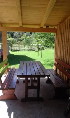 a wooden picnic table sitting under a pavilion at Apartment Korošec Matej in Bohinj