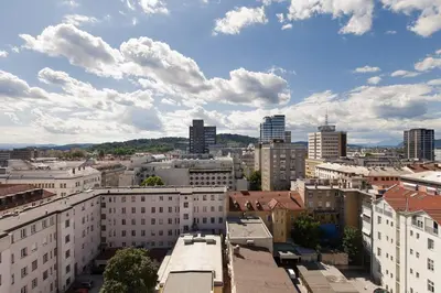 a view of a city with buildings and clouds at Charming Terrace Apartments Ana and Maria Tour As Ljubljana in Ljubljana