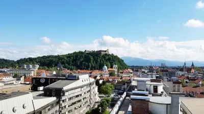 a view of a city with a hill in the background at Charming Terrace Apartments Ana and Maria Tour As Ljubljana in Ljubljana