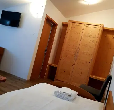 a bedroom with a bed and a chair and a cabinet at Gostišče Jazbec - Idrsko - Kobarid in Kobarid