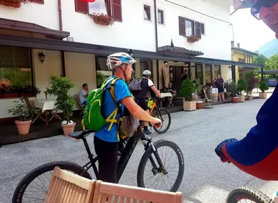 a man with a backpack standing with a bike at Gostišče Jazbec - Idrsko - Kobarid in Kobarid