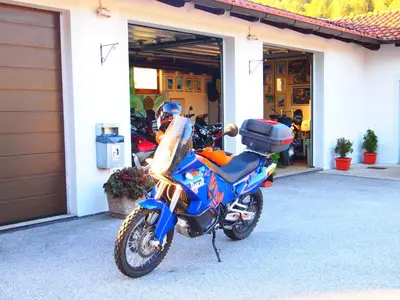a blue motorcycle parked outside of a garage at Gostišče Jazbec - Idrsko - Kobarid in Kobarid