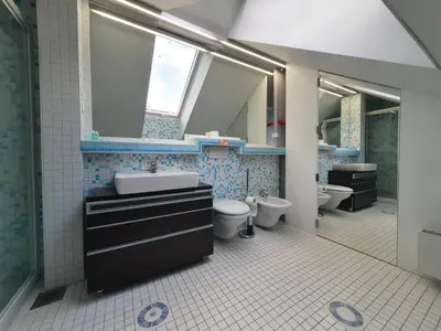 a bathroom with two toilets and a sink and mirrors at Jazz Apartment Tour As Ljubljana in Ljubljana
