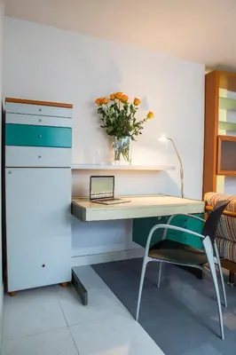 a desk and a chair with a vase of flowers at Jazz Apartment Tour As Ljubljana in Ljubljana