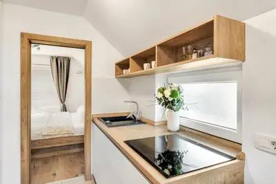 a small kitchen with a sink and a mirror at Apartments Svetina in Bled