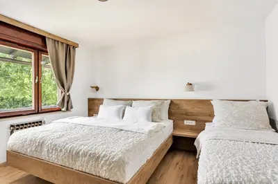 two beds in a bedroom with a window at Apartments Svetina in Bled