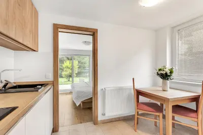 a small kitchen with a table and a mirror at Apartments Svetina in Bled