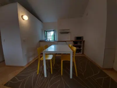 a dining room with a table and yellow chairs at Apartmaji Hedera in Komen