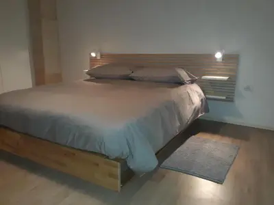 a bed with a wooden headboard in a bedroom at Apartmaji Hedera in Komen