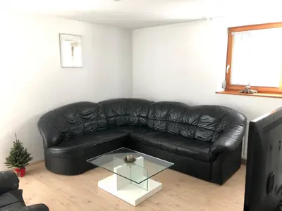 a black leather couch in a living room with a glass table at Katarina in Bled