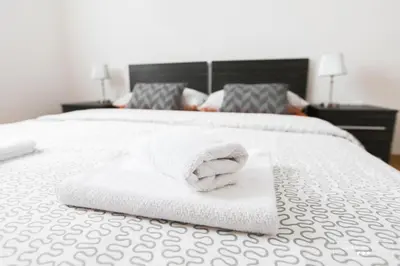 a pile of towels sitting on top of a bed at Luxurious RUBY Apartment with SAUNA in Kobarid