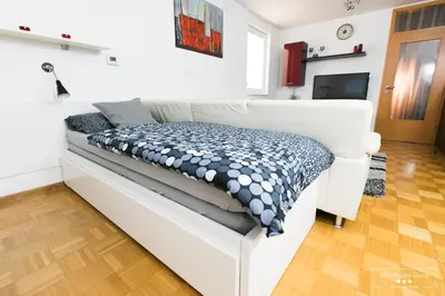 a white couch with a pillow on it in a living room at Luxurious RUBY Apartment with SAUNA in Kobarid