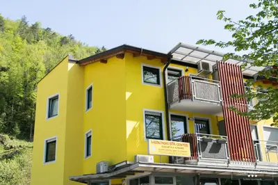 a yellow building with a balcony on top of it at Luxurious RUBY Apartment with SAUNA in Kobarid
