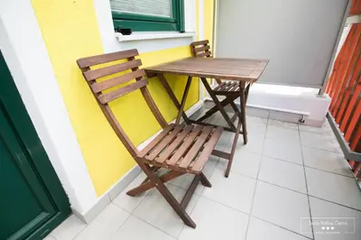 a wooden table and chair sitting next to a table and a window at Luxurious RUBY Apartment with SAUNA in Kobarid