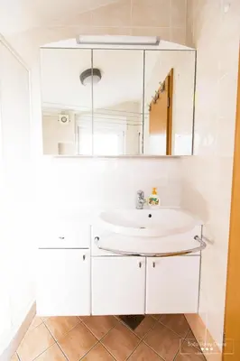 a bathroom with a white sink and a mirror at Luxurious RUBY Apartment with SAUNA in Kobarid
