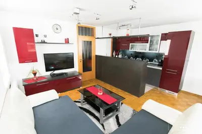 a living room with a couch and a kitchen at Luxurious RUBY Apartment with SAUNA in Kobarid