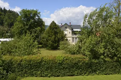 a large white house in the middle of trees at Vila Laura in Bled