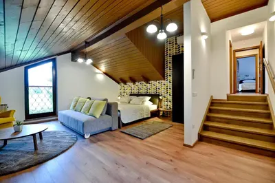 a living room with a couch and a bed and stairs at Vila Laura in Bled