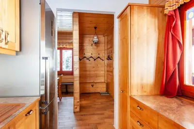 a kitchen with wood paneling and a dining room at Chalet Pokljuka in Goreljek
