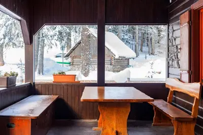 a room with a bench and a table and a window at Chalet Pokljuka in Goreljek