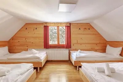 a room with three beds in a wooden house at Chalet Pokljuka in Goreljek