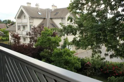 a large white house with trees and bushes on a balcony at Vila Apartment Bled Lake in Bled
