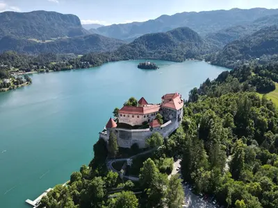 an island in the middle of a lake with a castle at Vila Apartment Bled Lake in Bled