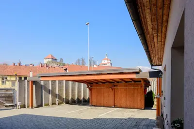 a building with a wooden garage with a fence at ABC apartments in Kamnik