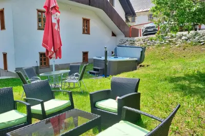 a group of chairs and a table and umbrella on a yard at Jacobs Resort House Planica in Kranjska Gora