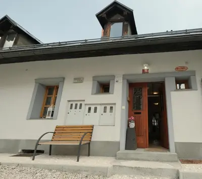 a bench in front of a white building at Jacobs Resort House Planica in Kranjska Gora