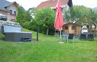 a yard with a table and an umbrella and chairs at Jacobs Resort House Planica in Kranjska Gora