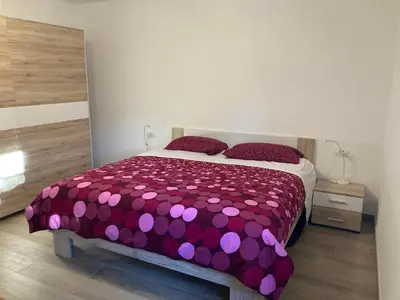 a bedroom with a purple bed with purple pillows at First Vrtovin Apartment in Črniče